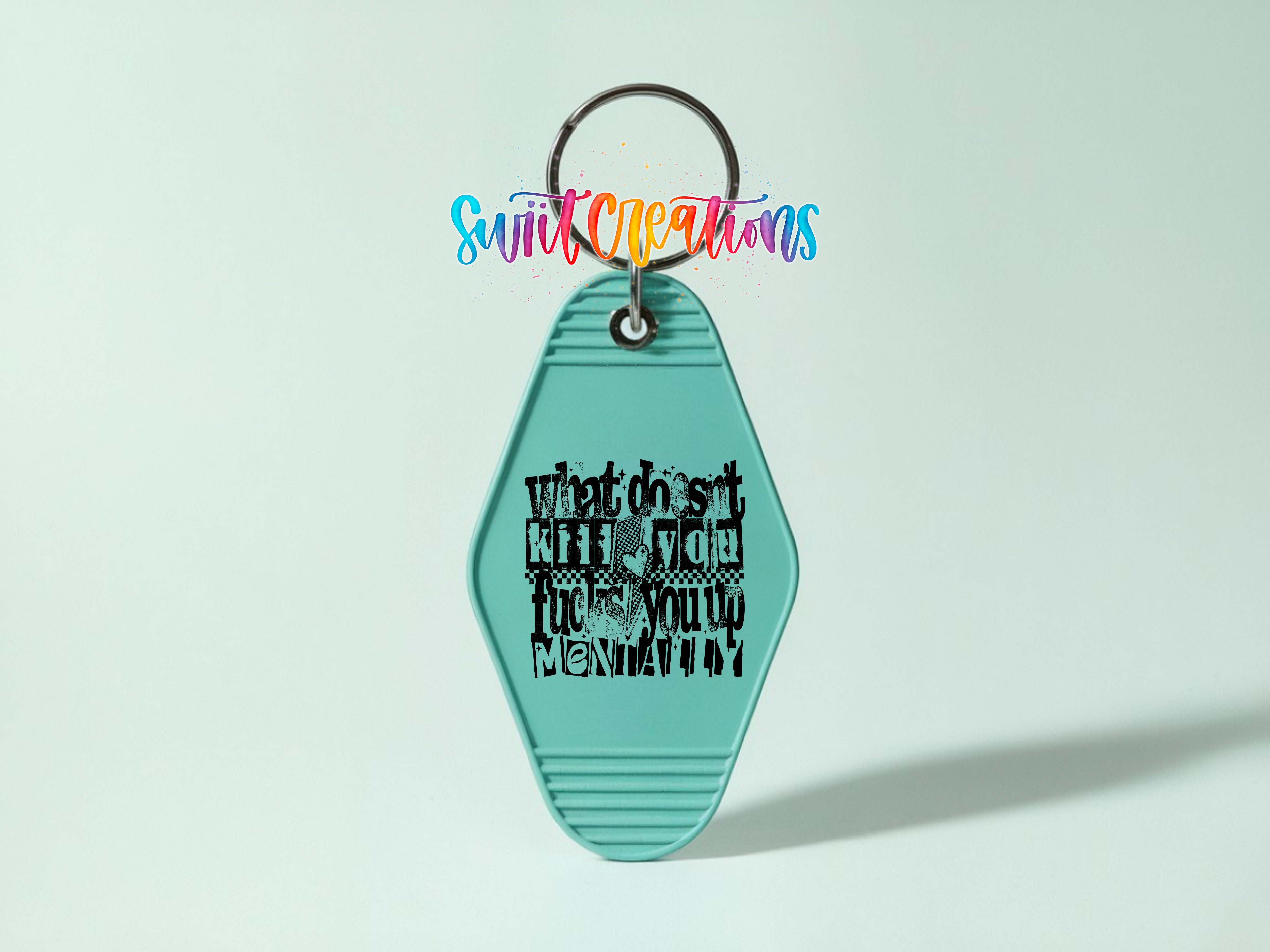 A turquoise keychain with a black text design on it, which appears to be a humorous or tongue-in-cheek message.