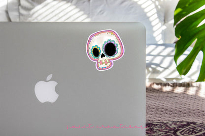 a laptop with a sticker of a skull on it