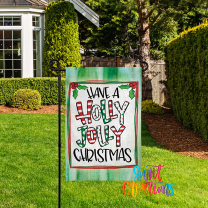A yard sign with the text "Have a Holly Jolly Christmas" displayed on it, placed in a grassy area with a house and trees in the background.