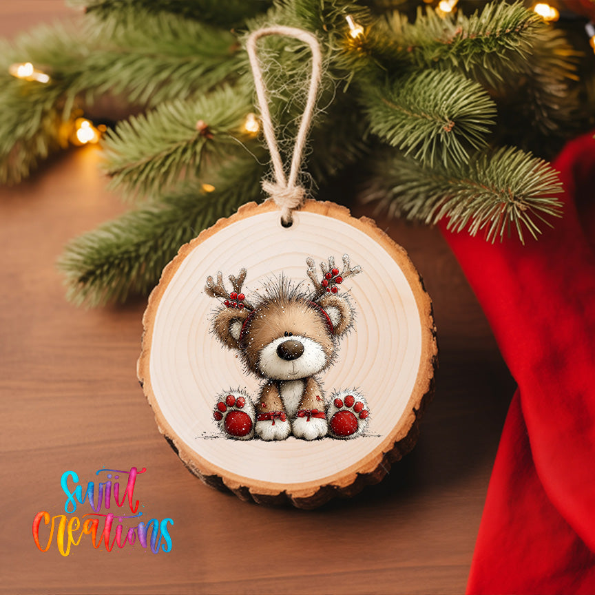 A wooden ornament featuring a cute reindeer with antlers is hanging on a Christmas tree, surrounded by pine branches and twinkling lights.