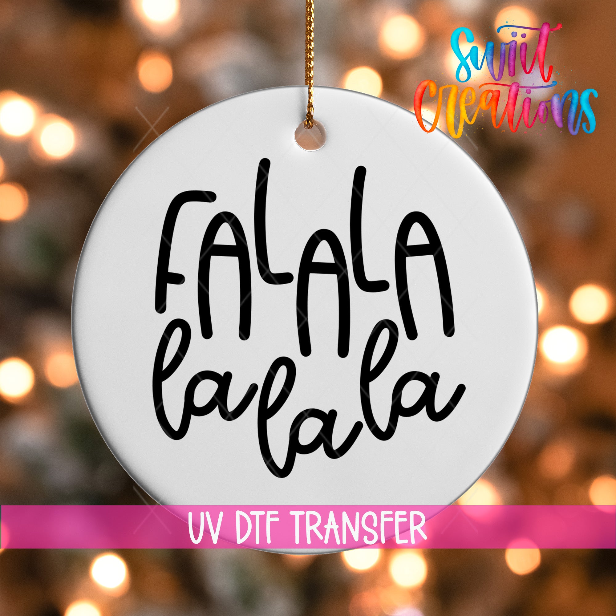 A white oval ornament with the text "FALA la la la" written on it, hanging against a background of colorful lights.