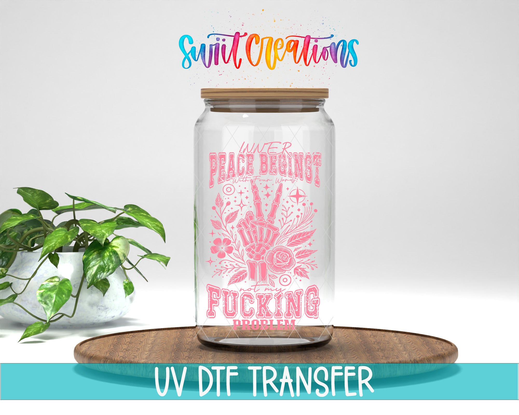 A glass jar with a pink and white design, featuring a hand holding a peace sign and the text "Peace begins with Fucking Proverbs". The jar is placed on a wooden surface, and there is a potted plant in the background.