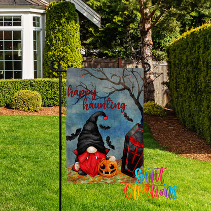 A Halloween-themed garden sign featuring a gnome, a jack-o-lantern, and bats against a spooky background.