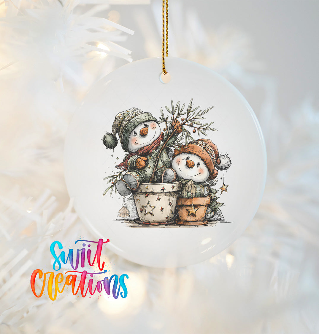 A white ornament with a snowman and a pot of flowers hanging on a Christmas tree.