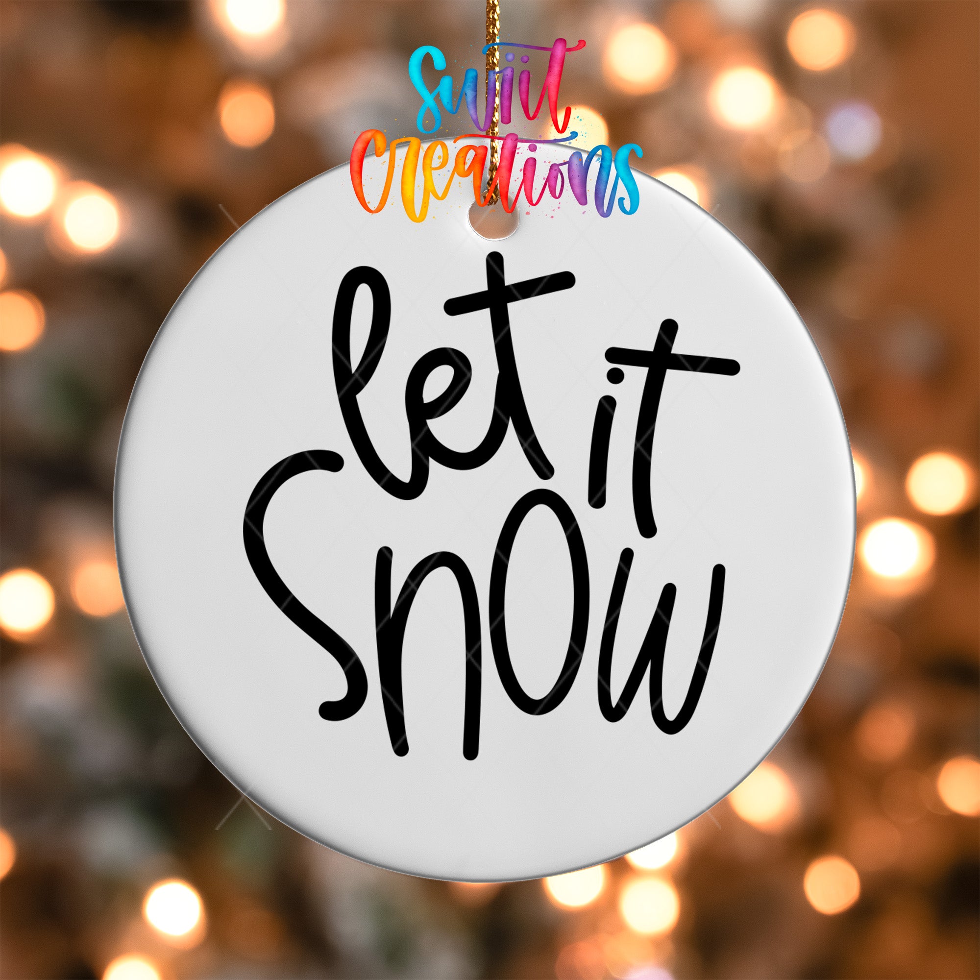 A white circular ornament with the text "let it snow" written on it.
