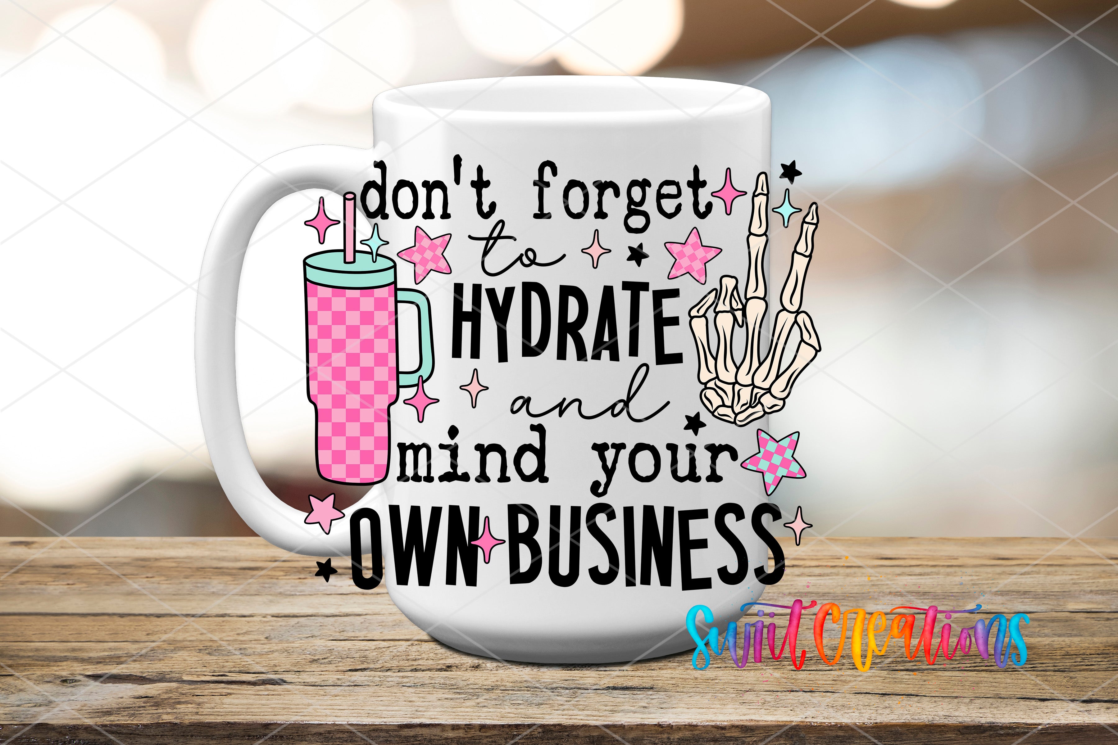 A white mug with a colorful design and text on it, placed on a wooden surface.