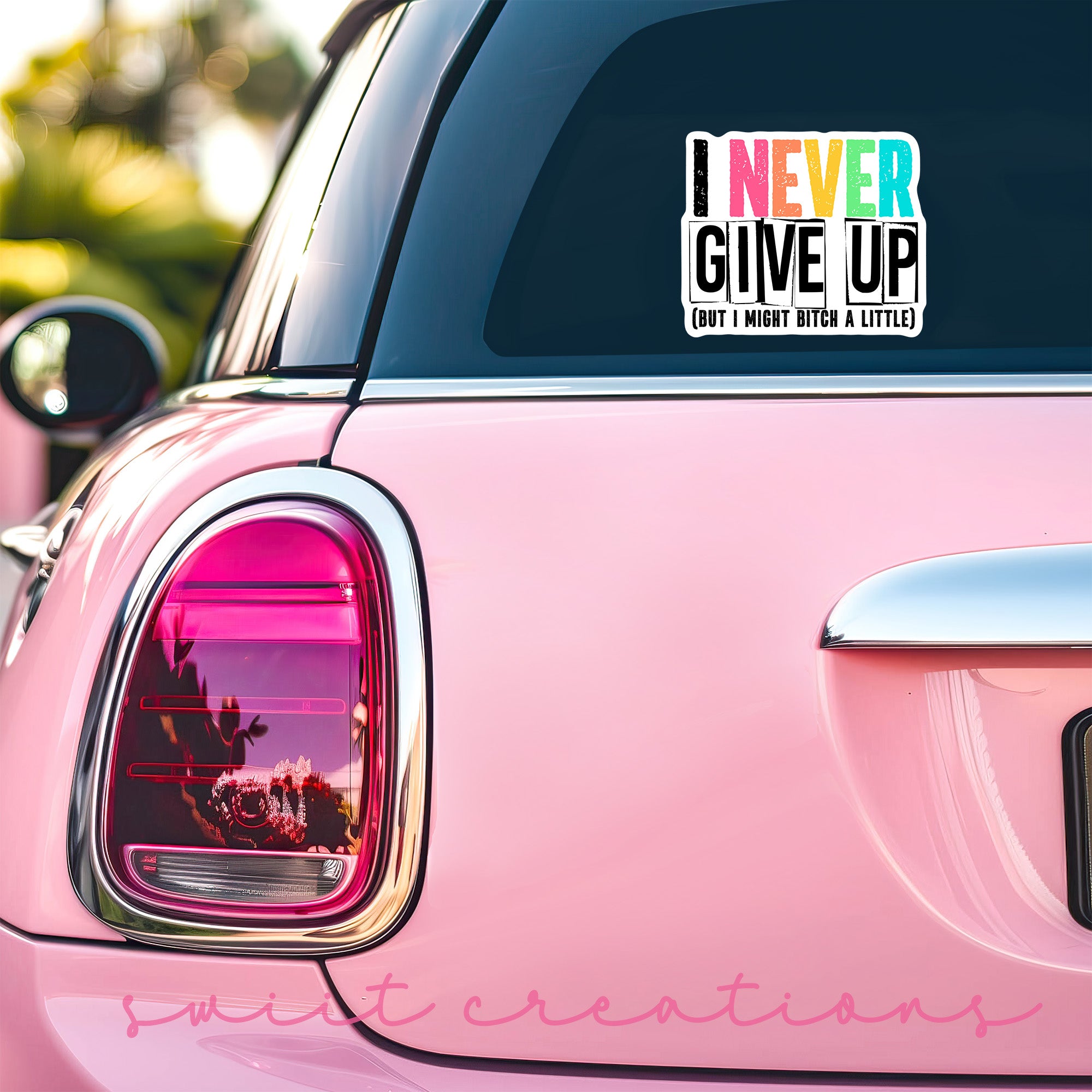 a pink car with a sticker that says i never give up