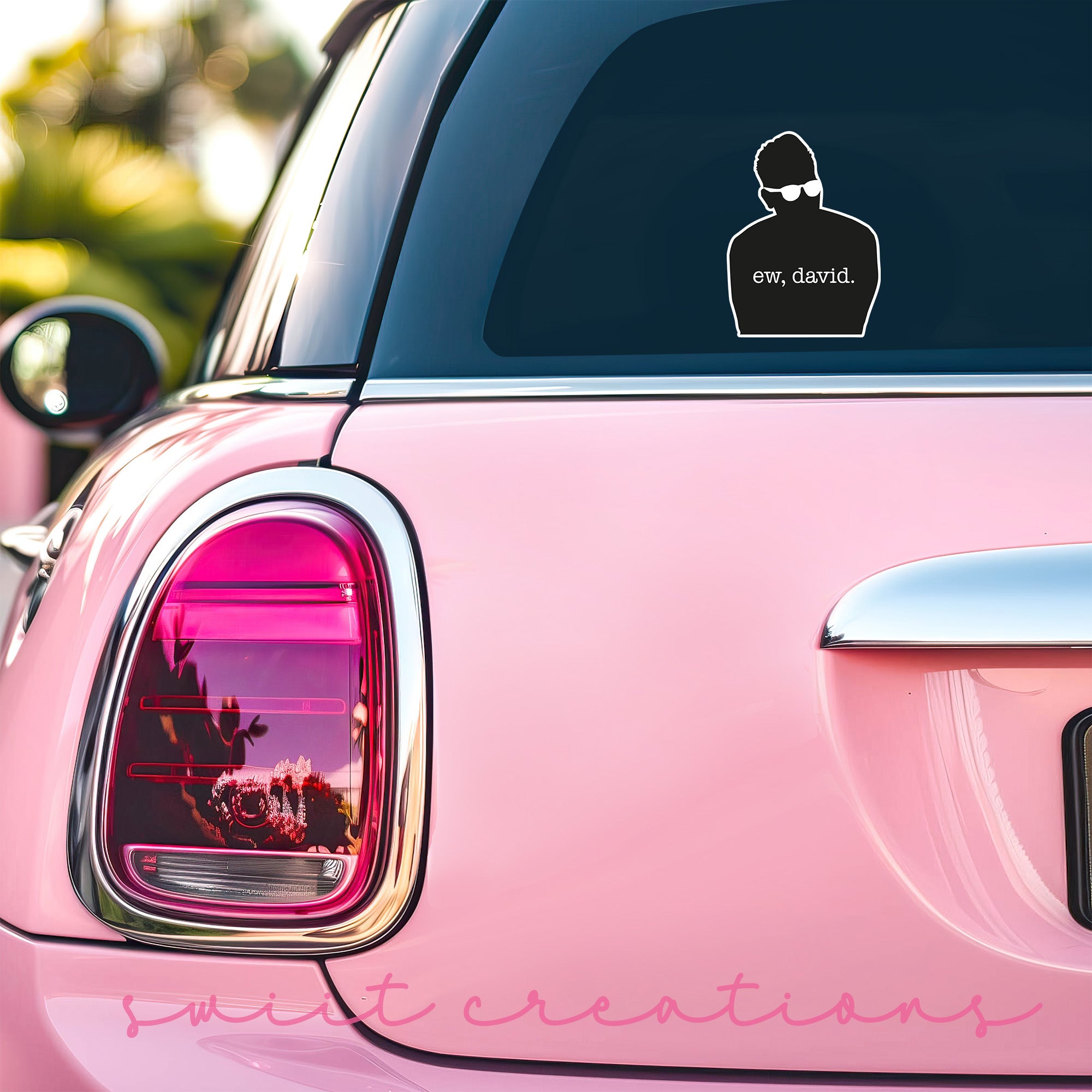 a pink car with a sticker on the back of it
