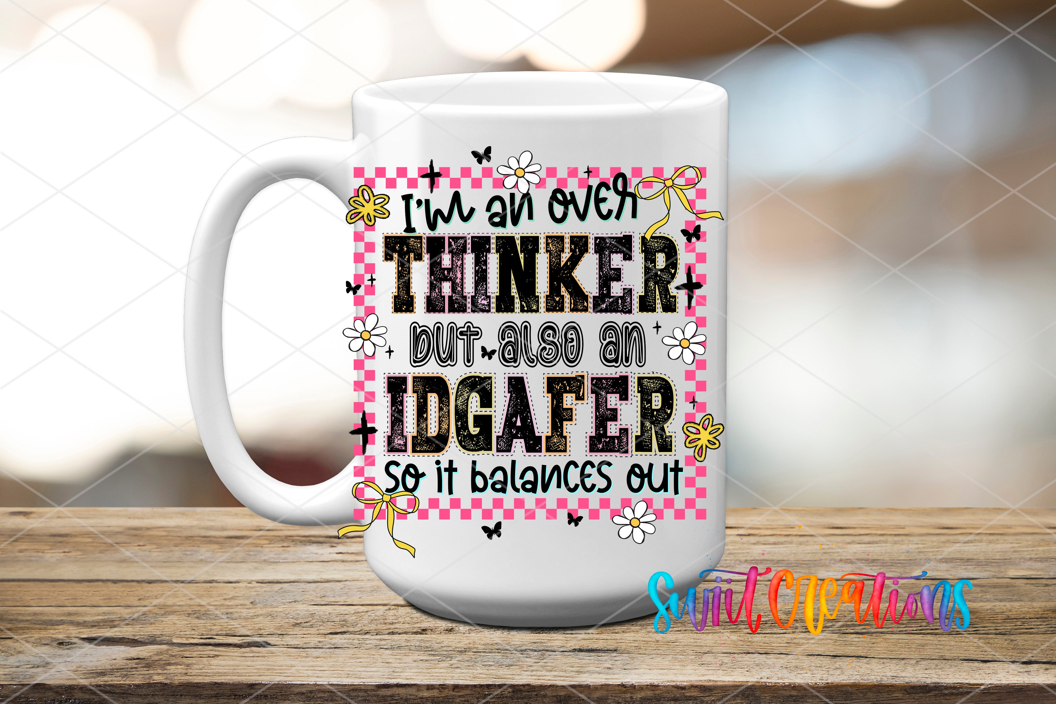 A white mug with a colorful design and text on it, placed on a wooden surface.