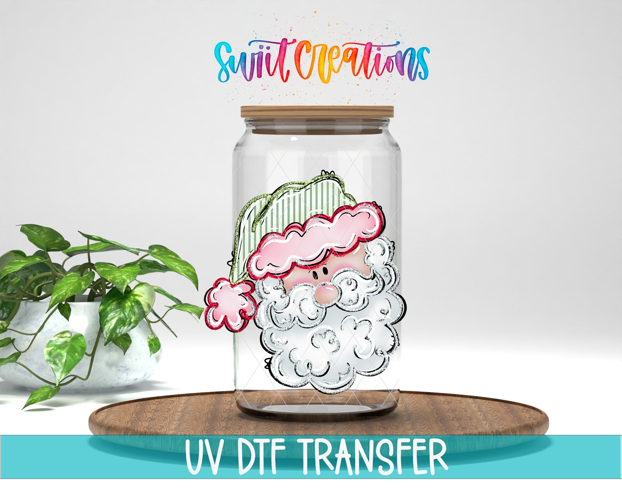 a glass jar with a Santa Claus drawing inside, placed on a wooden surface. There is a potted plant to the left of the jar, and the background is white.