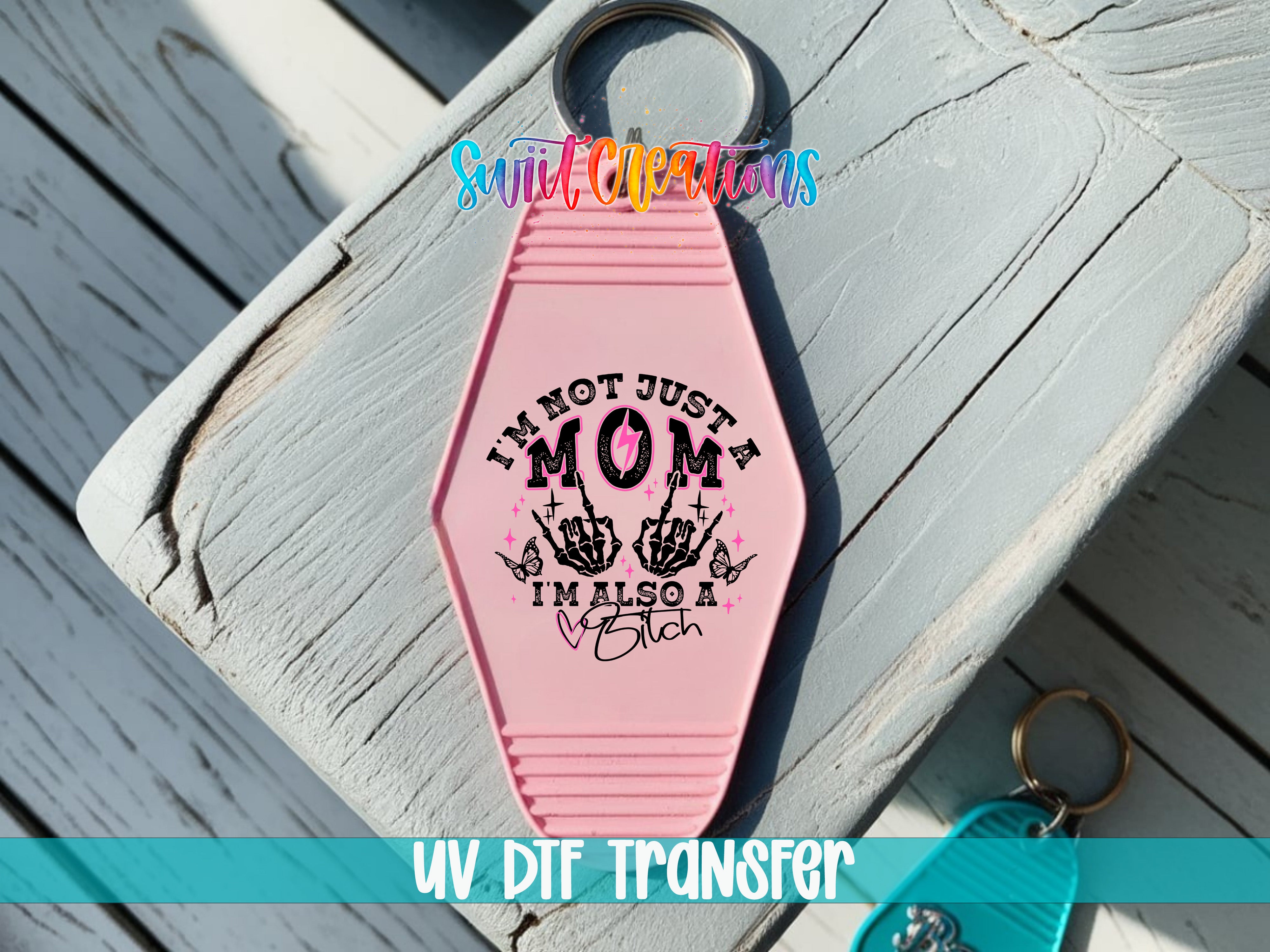 A pink keychain with a message printed on it, placed on a wooden surface.