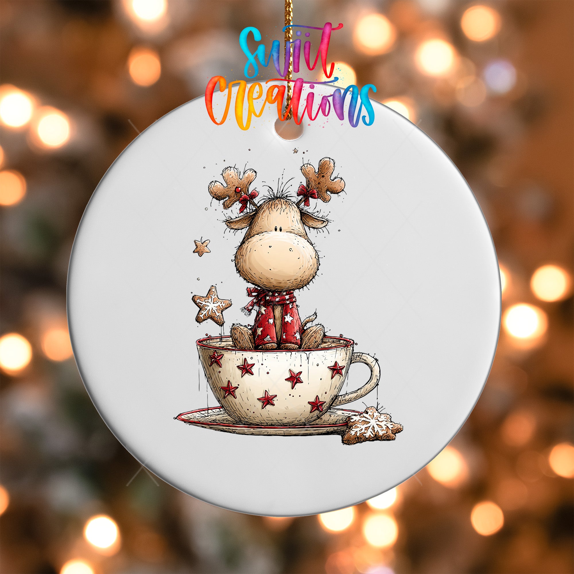 A white ceramic ornament with a cartoon image of a reindeer sitting in a cup of coffee, surrounded by stars and a cookie.