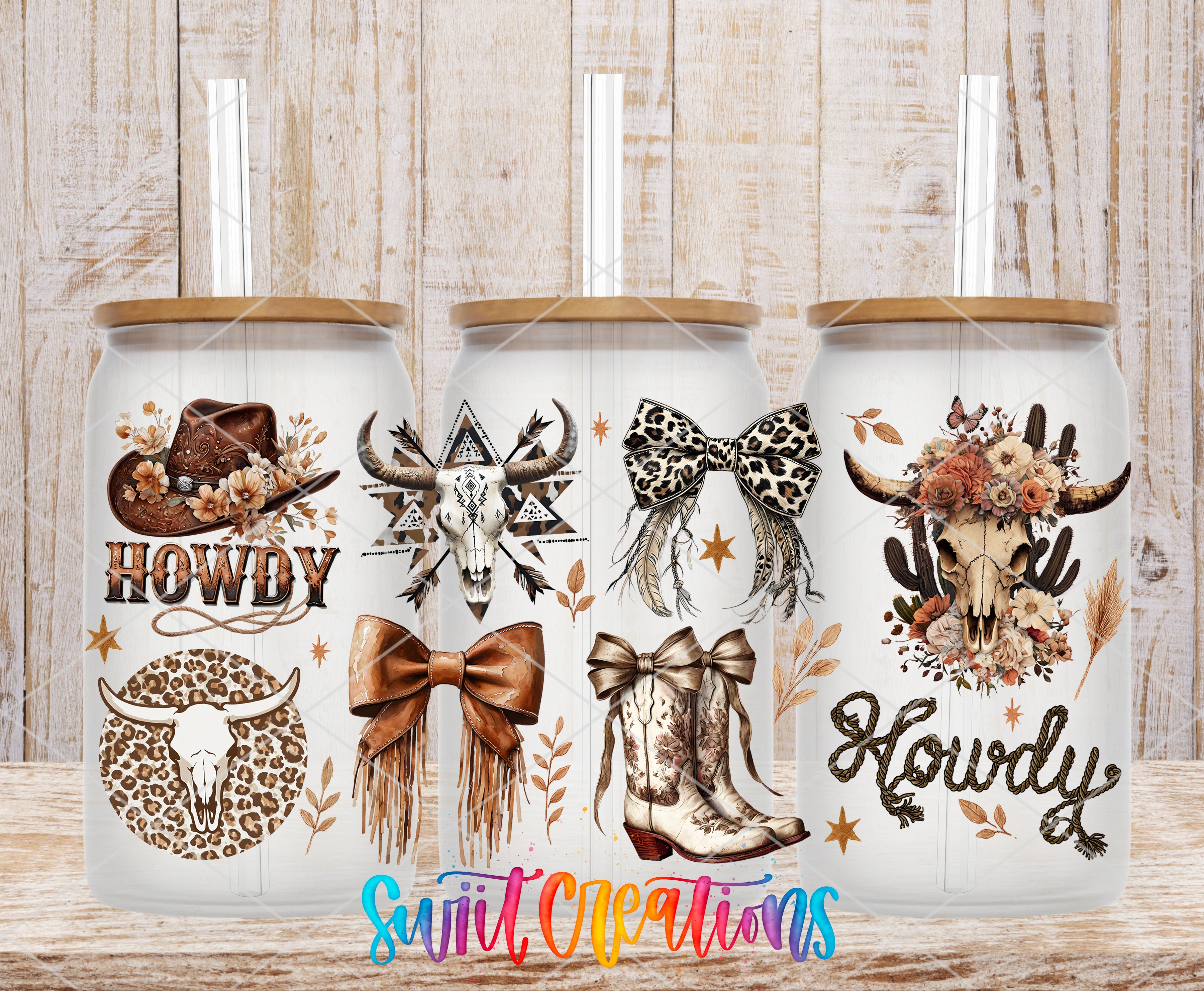 Three white tumblers with various western-themed designs and text printed on them, placed on a wooden surface.
