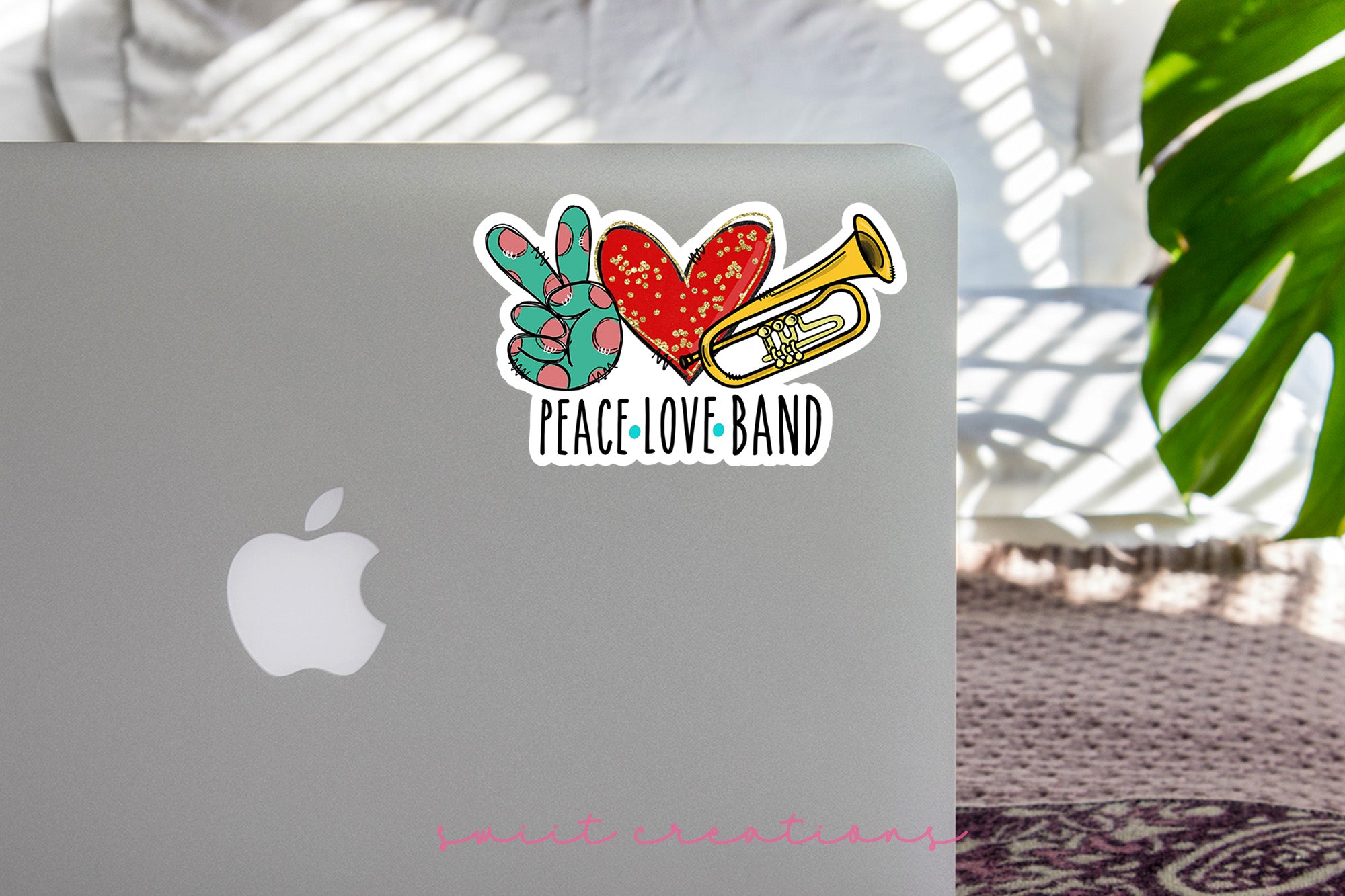 a laptop with a sticker of a trumpet and heart
