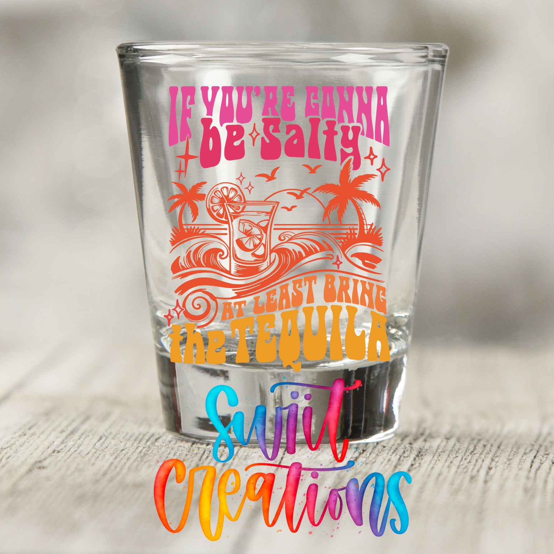 a colorful shot glass with a text design on it.