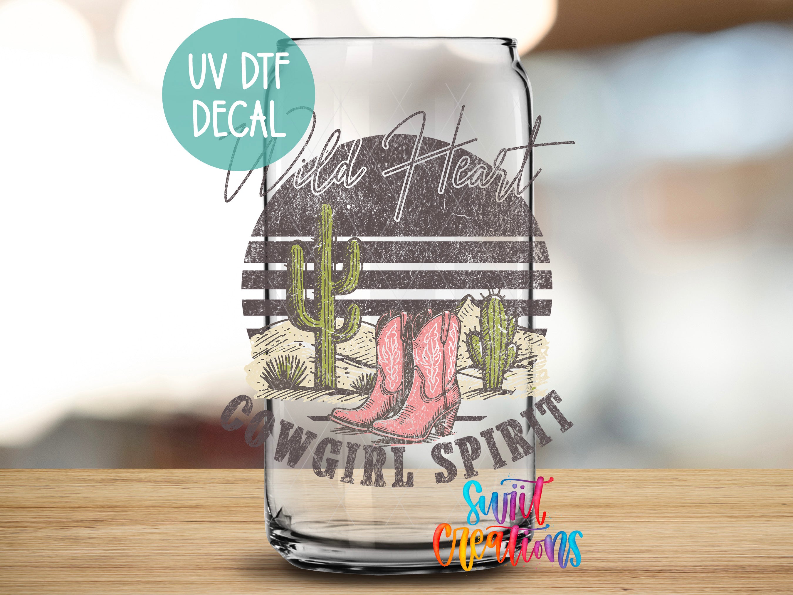 A glass jar with a UV decal featuring a cowboy-themed design, including a cactus, boots, and the text "Wild Heart" and "COWGIRL SPIRIT".