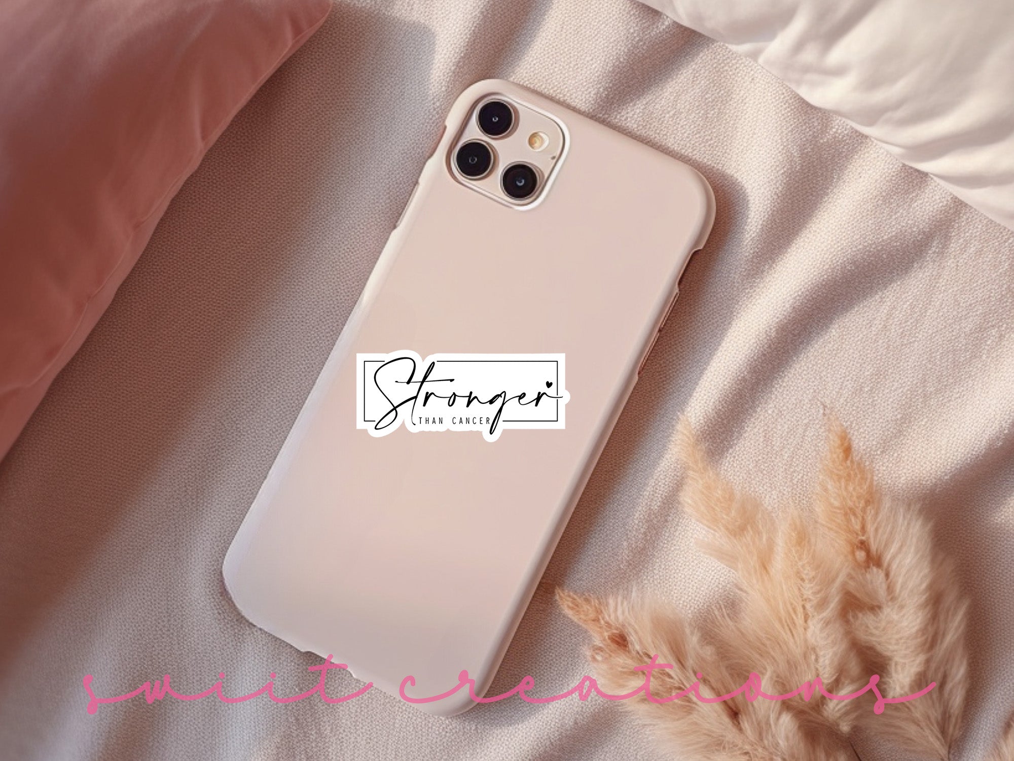 a phone case with a sticker on it sitting on a bed