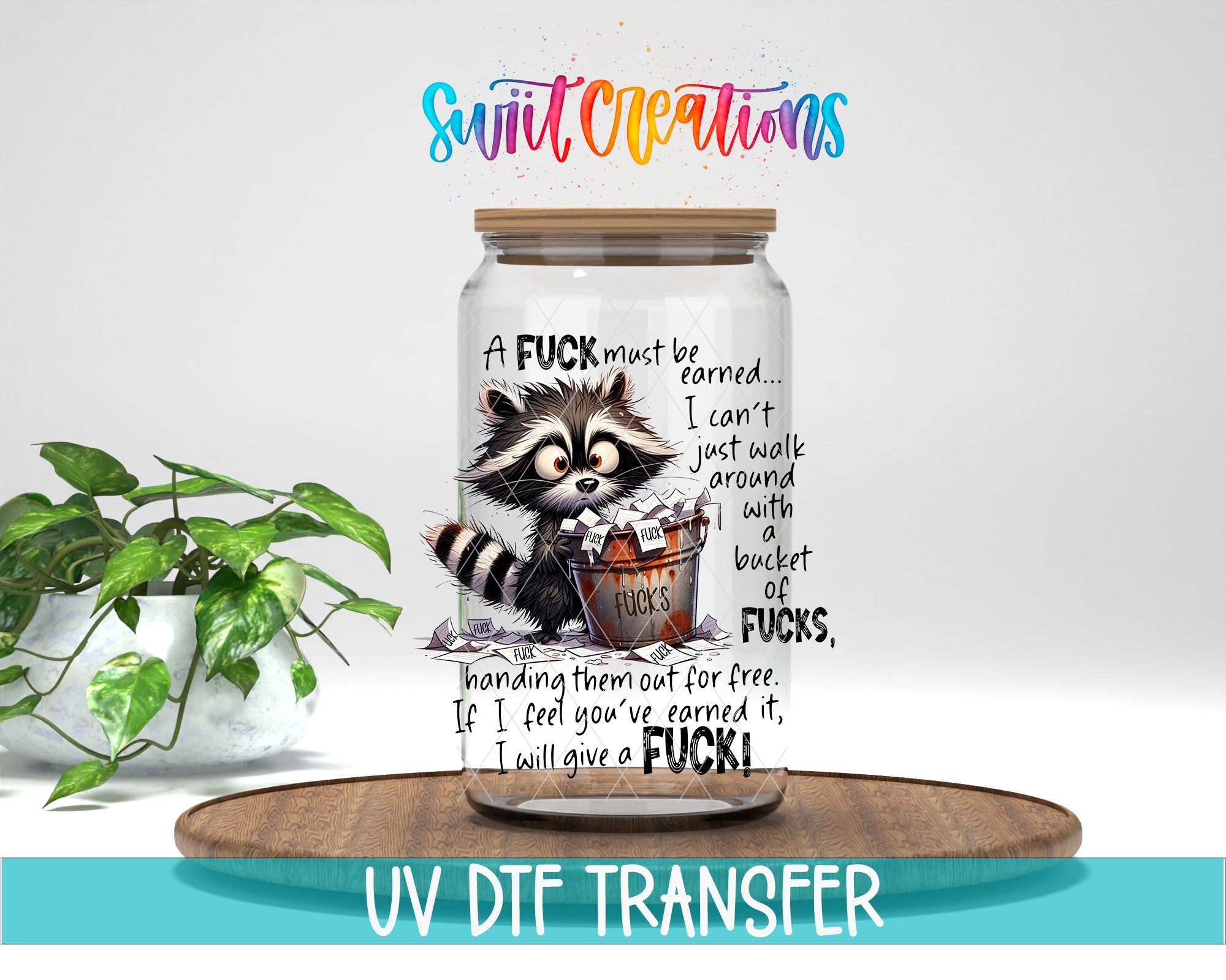 A jar with a raccoon graphic and text, placed on a wooden surface next to a potted plant.