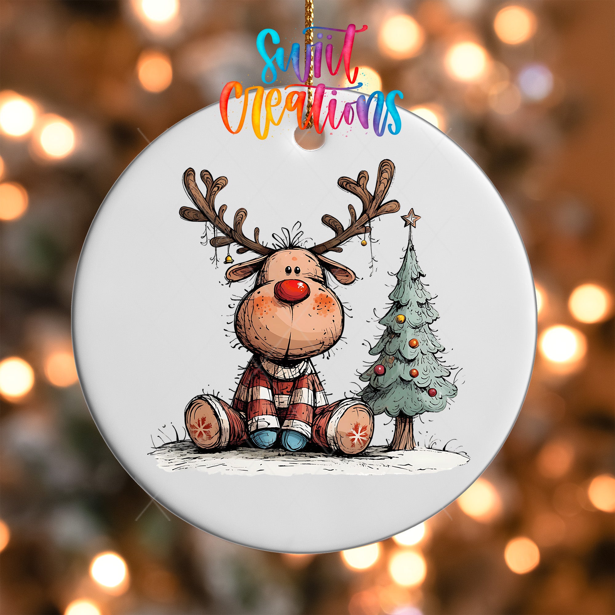 A white ornament featuring a cartoon reindeer sitting next to a Christmas tree.