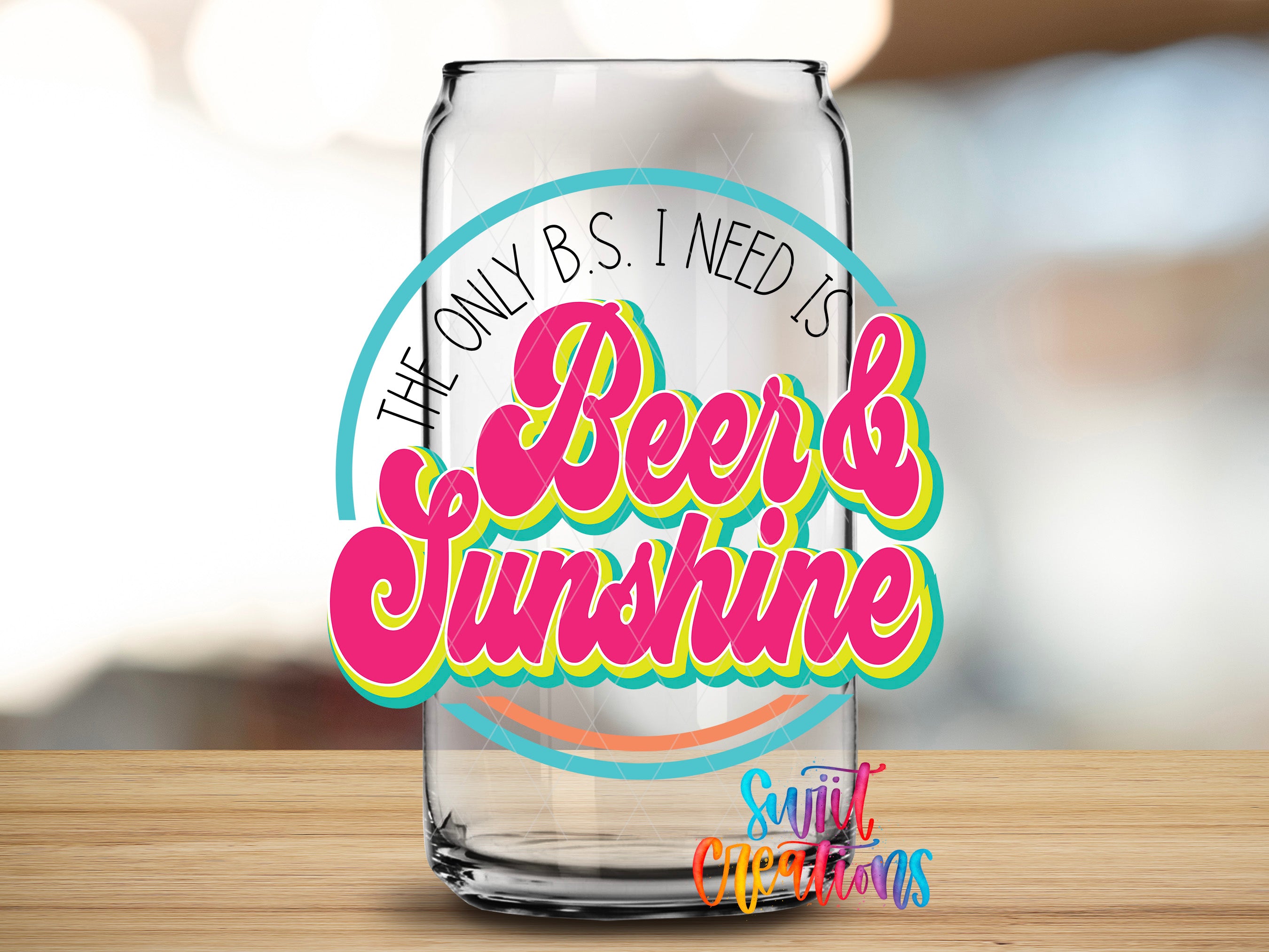 a clear glass can with a colorful, retro-style text design on it, placed on a wooden surface.