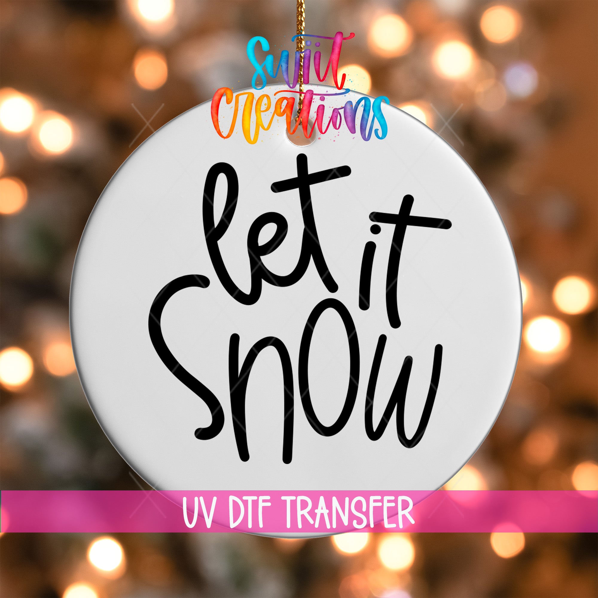 A white circular ornament with the text "Let it Snow" written on it, hanging against a background of colorful lights.