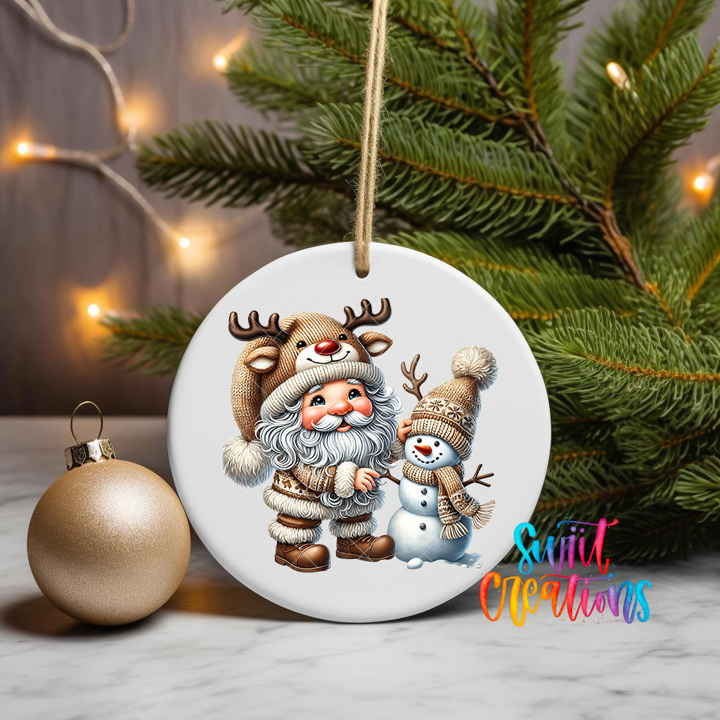 A white ceramic ornament featuring Santa Claus and a snowman, with a Christmas tree and twinkling lights in the background.