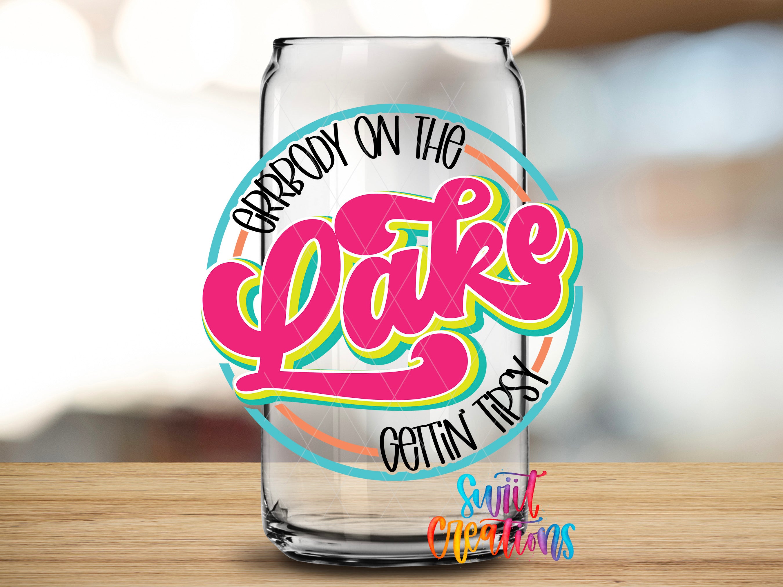 A glass can with a colorful design featuring the text "Grrbody on the Lake" and "Gotin Tippy" written on it.