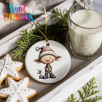 a Christmas ornament with a cartoon elf, a glass of milk, cookies, and greenery.