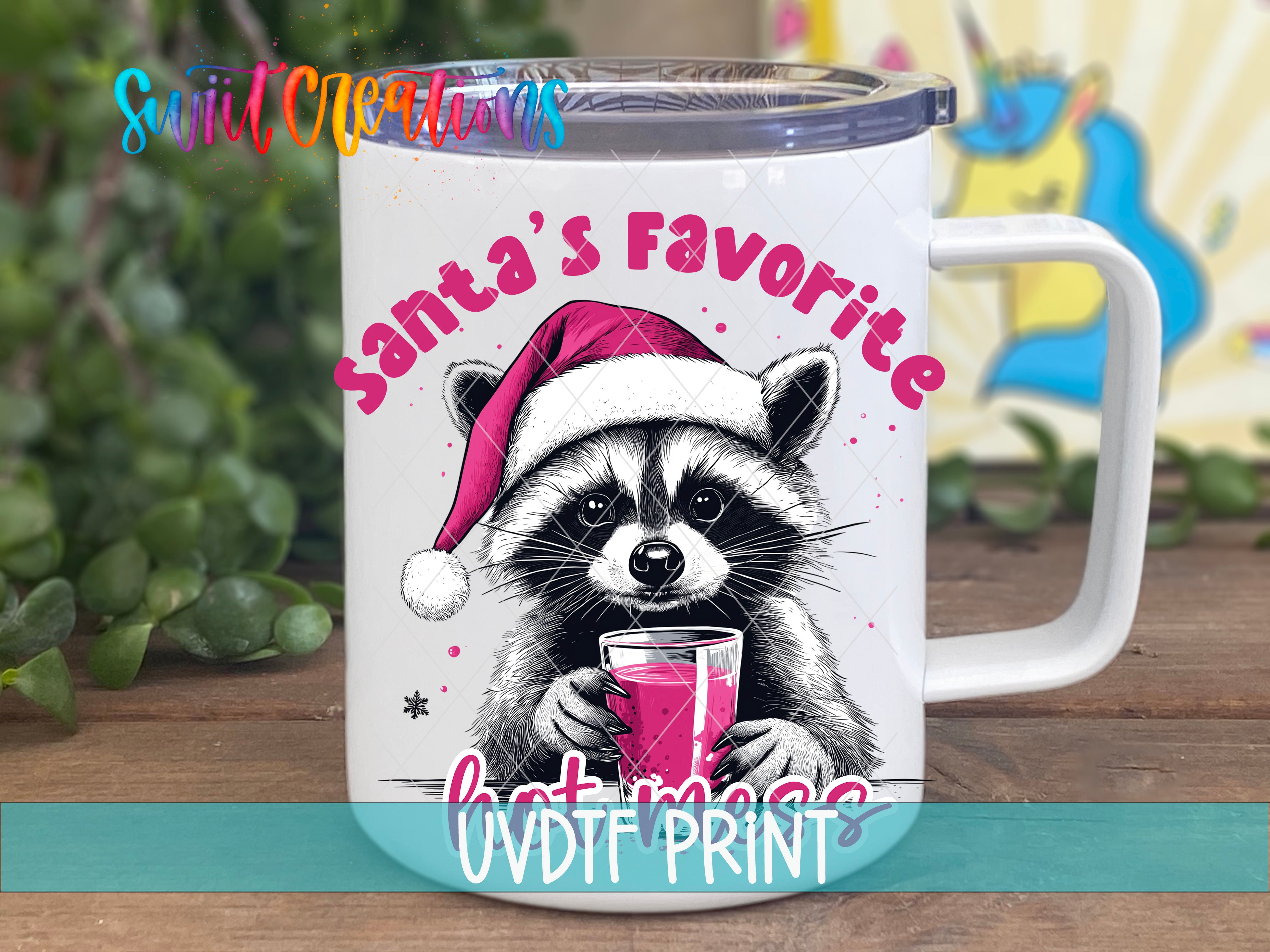 A mug with a raccoon wearing a Santa hat and holding a drink, with the text "Santa's Favorite Hot Mess" printed on it.