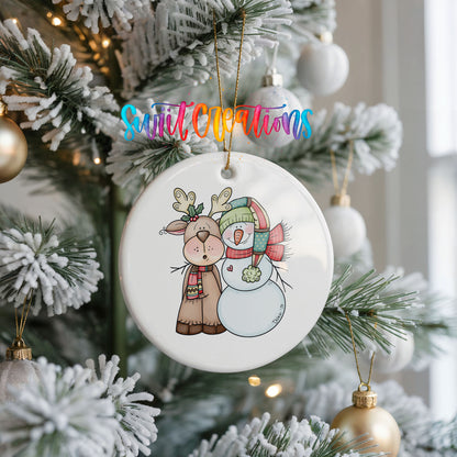 Round ceramic reindeer and snowman ornament on a snowy Christmas tree