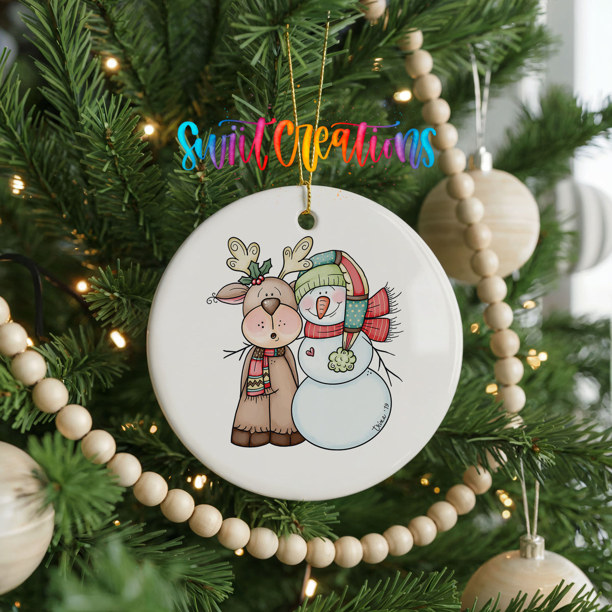 Reindeer and snowman Christmas ornament hanging on a decorated tree
