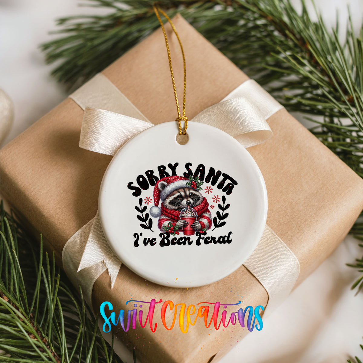 Sorry Santa I've Been Feral funny raccoon ceramic Christmas ornament arranged on a wrapped Christmas gift
