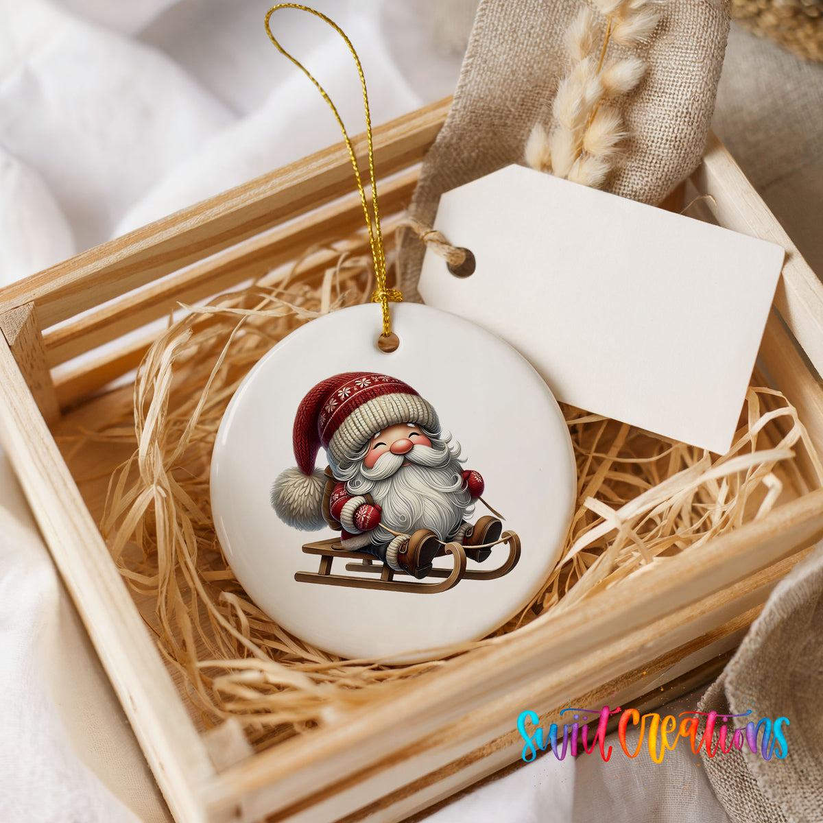 Sleeping Santa on a sled ceramic Christmas ornament displayed in a rustic wooden gift crate