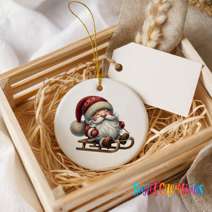 Sleeping Santa on a sled ceramic Christmas ornament displayed in a rustic wooden gift crate