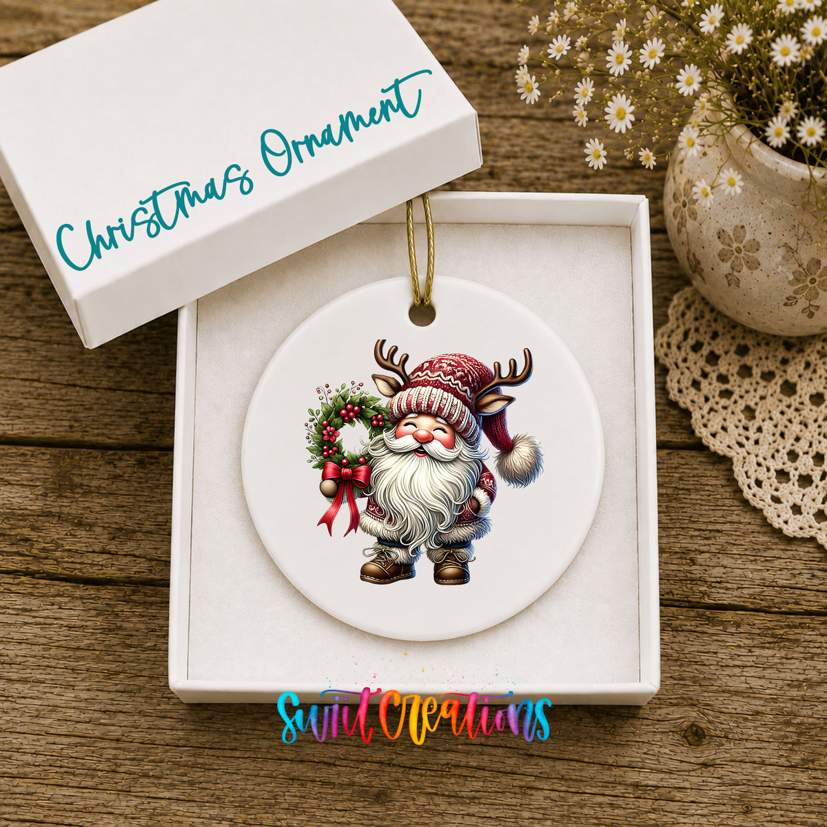 Cozy Santa holding a Christmas wreath ceramic ornament displayed in the included gift box