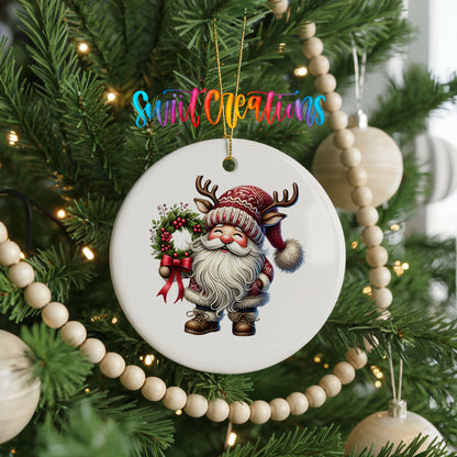 Cozy Santa holding a Christmas wreath ceramic ornament hanging on a decorated Christmas tree