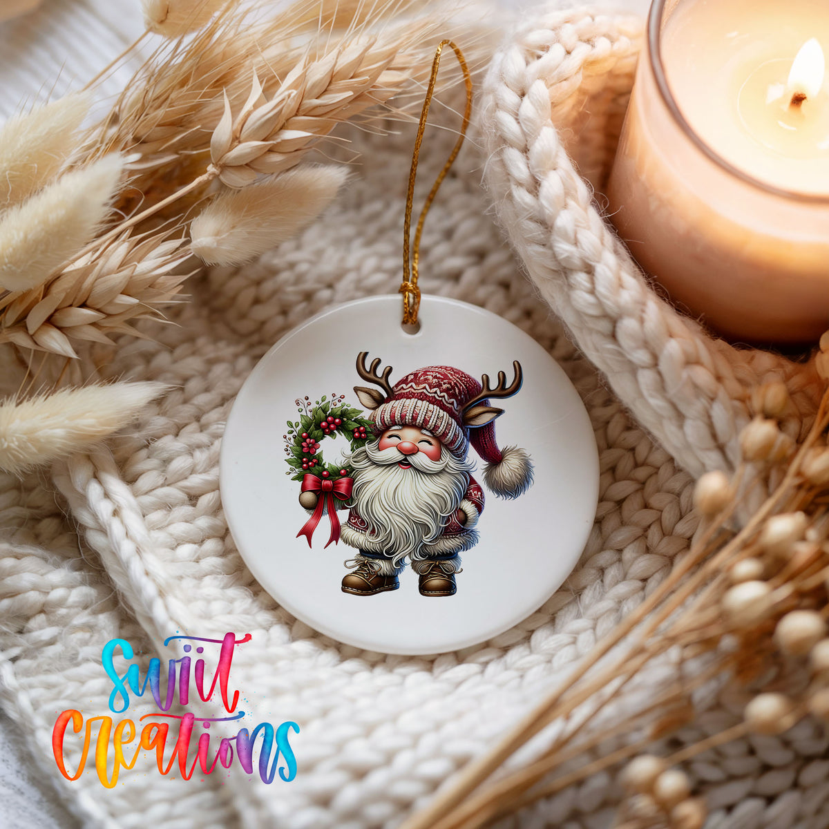 Cozy Santa holding a Christmas wreath ceramic ornament styled beside a candle and cozy knit blanket