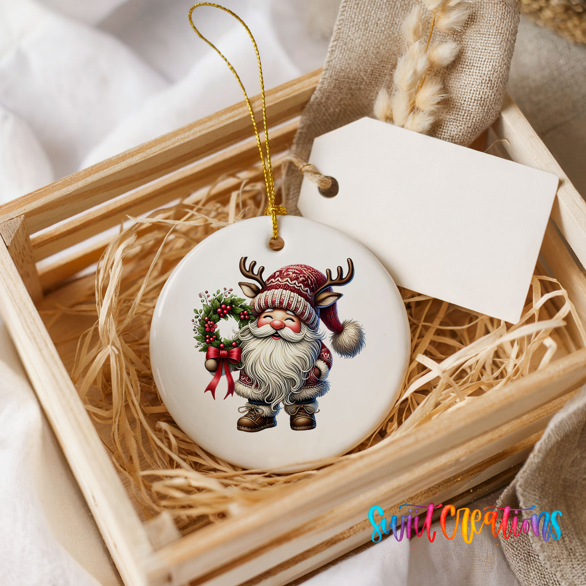 Cozy Santa holding a Christmas wreath ceramic ornament displayed in a rustic wooden gift crate