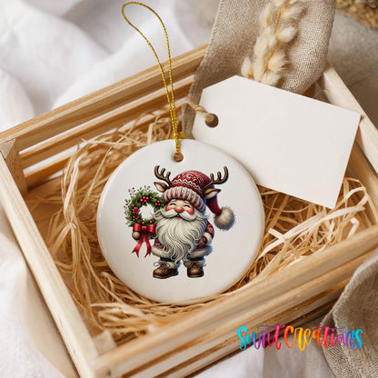 Cozy Santa holding a Christmas wreath ceramic ornament displayed in a rustic wooden gift crate