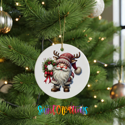 Cozy Santa holding a Christmas wreath ceramic ornament hanging on a green Christmas tree