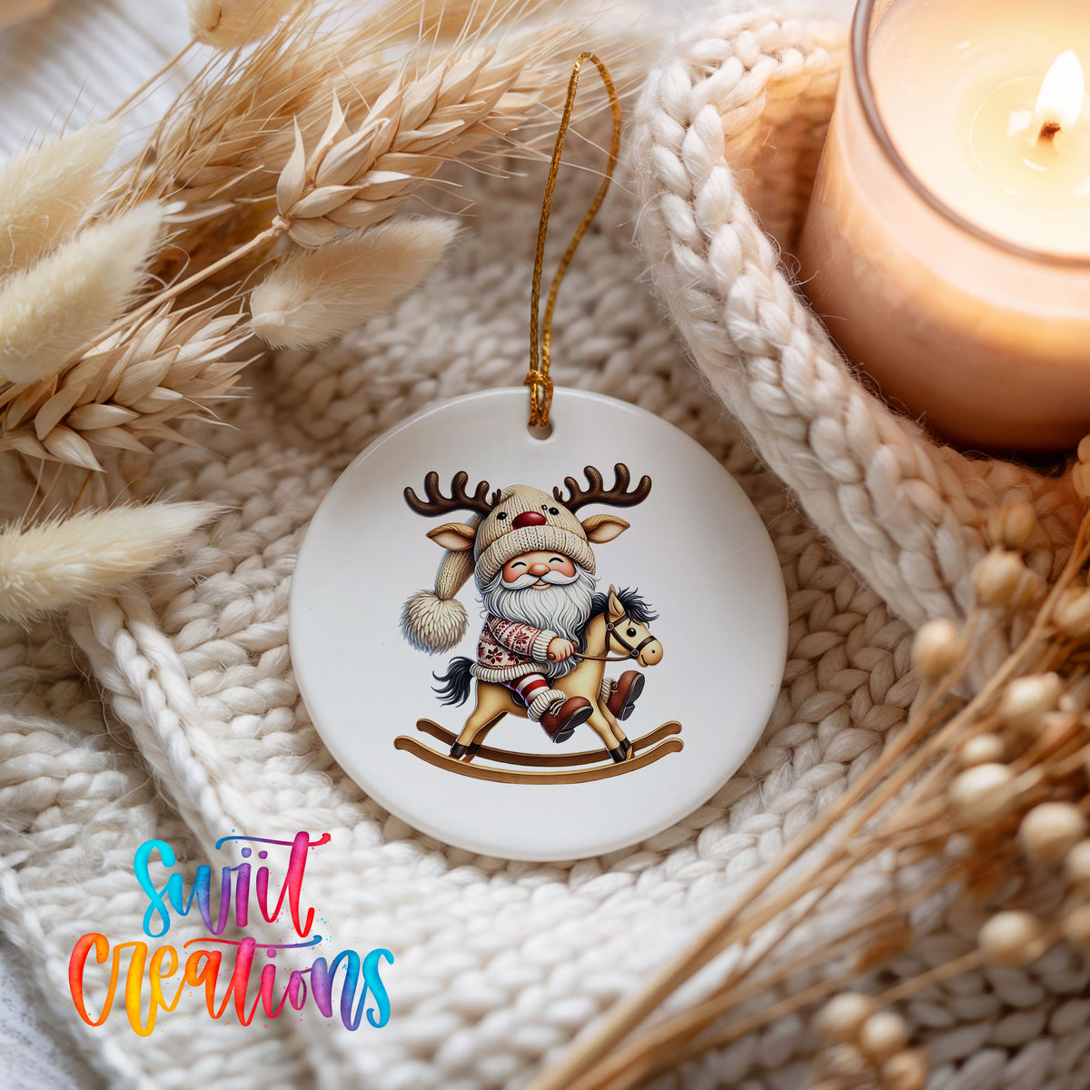 Whimsical Santa riding a rocking horse ceramic Christmas ornament styled beside a candle and cozy knit blanket