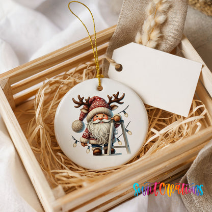 Santa decorating Christmas lights ceramic ornament displayed in a rustic wooden gift crate