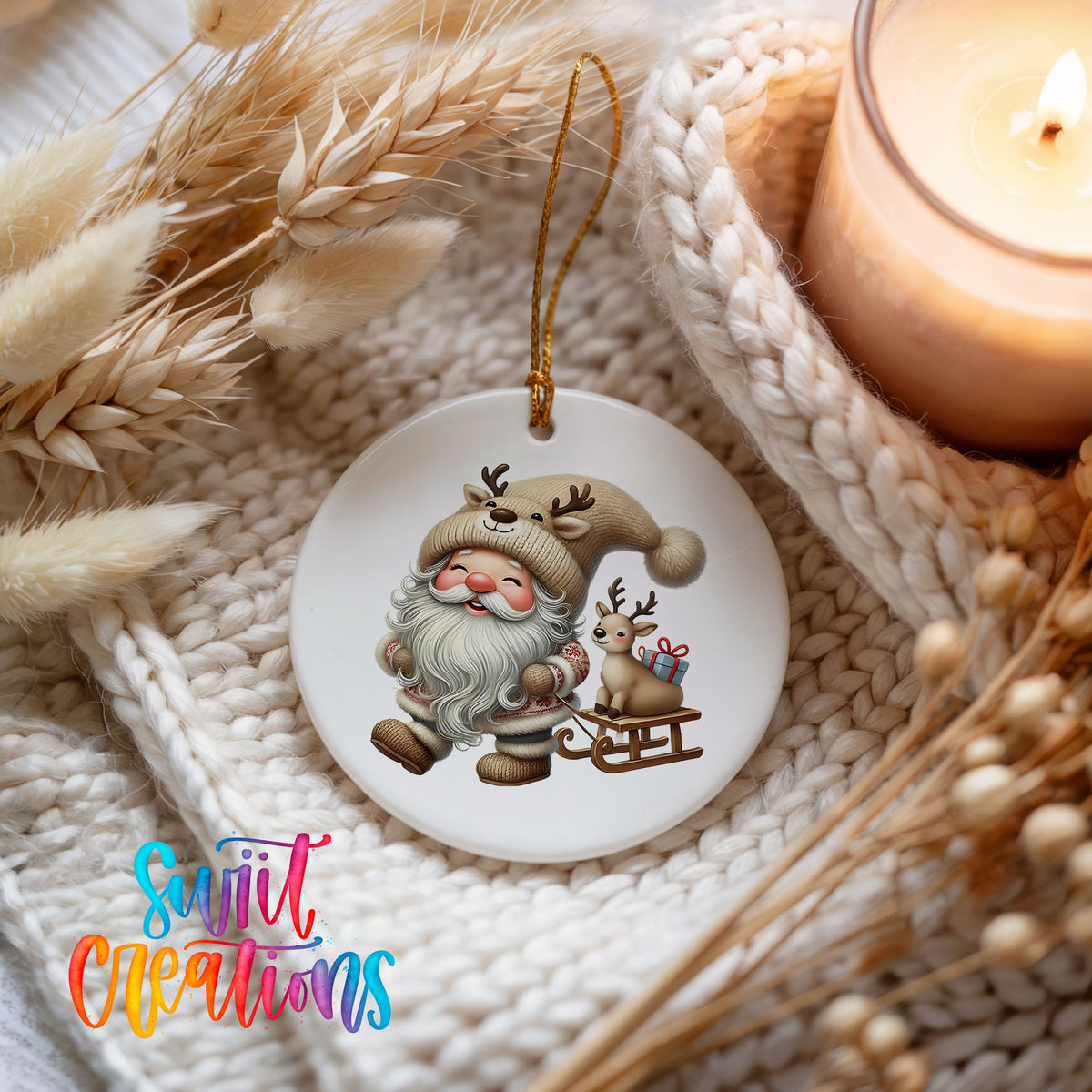 Santa pulling a reindeer sled ceramic Christmas ornament styled beside a candle and cozy knit blanket