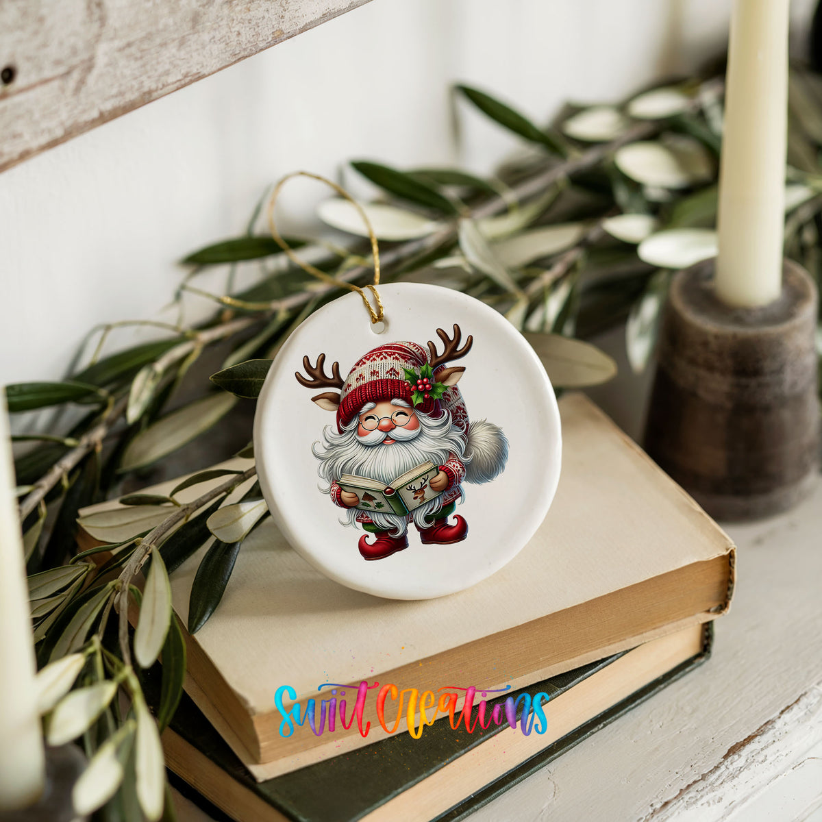 Santa reading a Christmas story ceramic ornament styled on books with holiday greenery