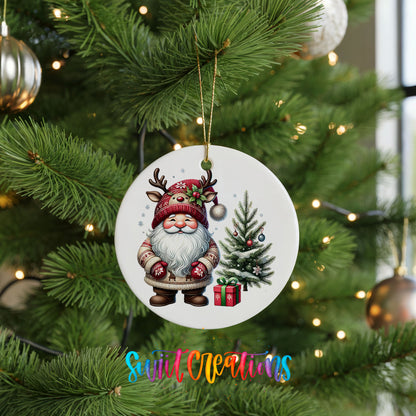 Santa beside a Christmas tree and wrapped gift ceramic Christmas ornament hanging on a green Christmas tree