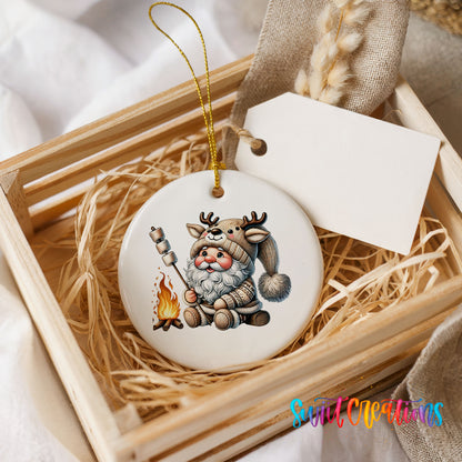 Santa roasting a marshmallow by a campfire ceramic Christmas ornament displayed in a rustic wooden gift crate