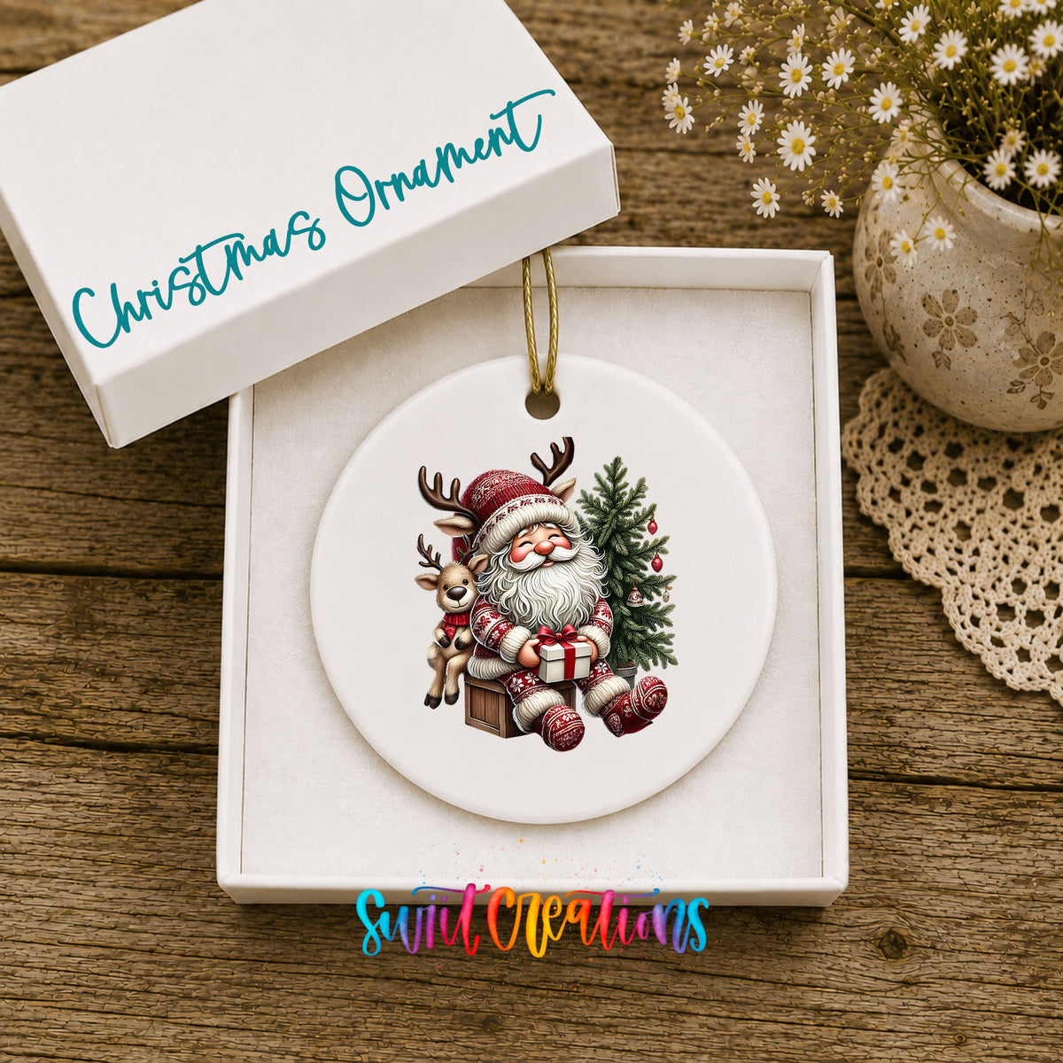 Round ceramic Christmas ornament featuring Santa with a reindeer beside a decorated Christmas tree, displayed in the included gift box
