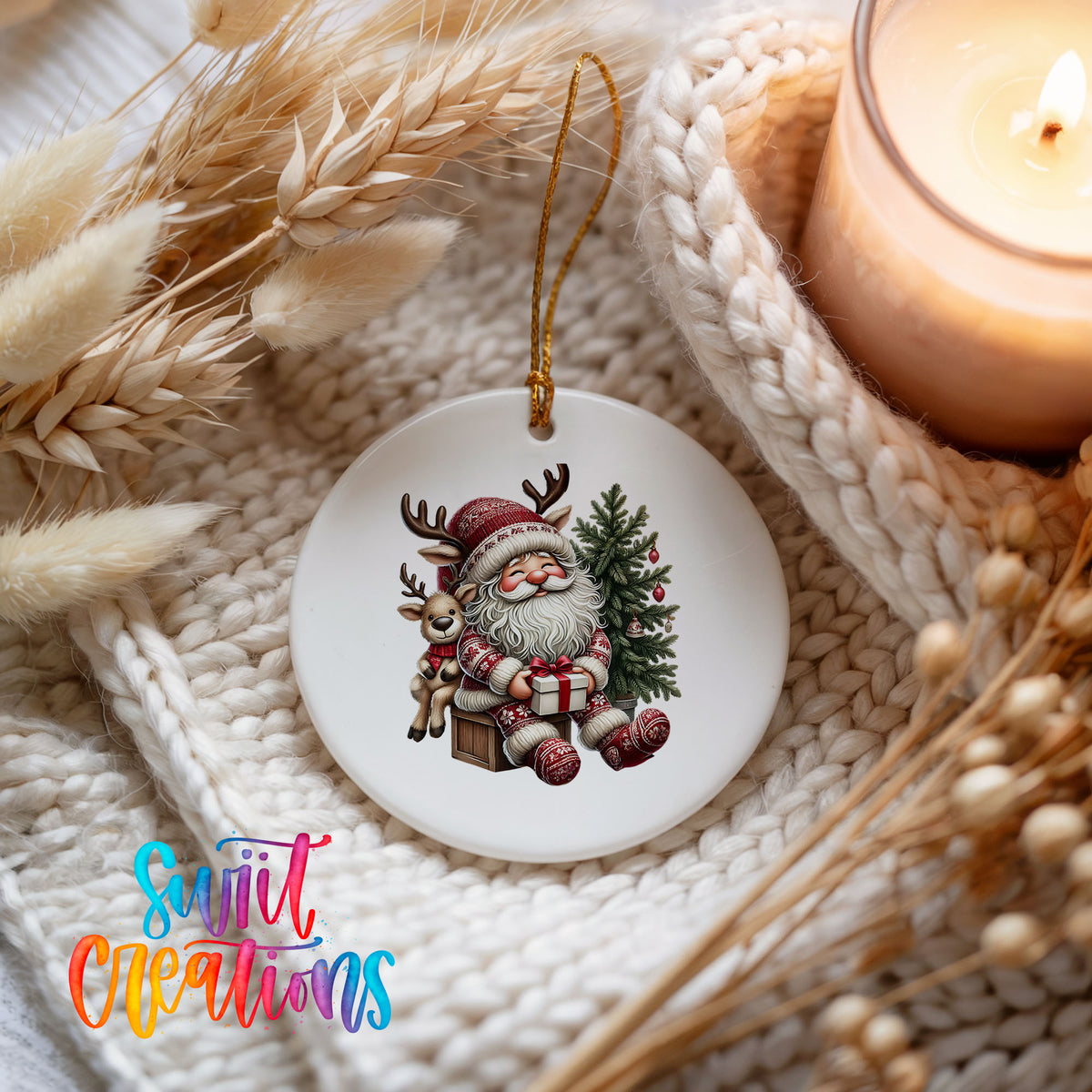 Round ceramic Christmas ornament featuring Santa with a reindeer beside a decorated Christmas tree, styled beside a candle and cozy knit blanket