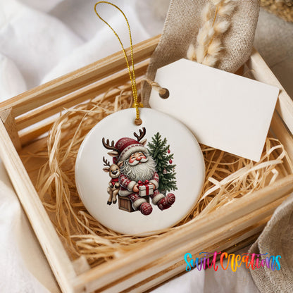Round ceramic Christmas ornament featuring Santa with a reindeer beside a decorated Christmas tree, presented in a rustic wooden gift crate