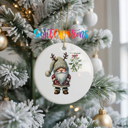 Round ceramic Christmas ornament featuring Santa standing beneath Christmas mistletoe, hanging on a frosted Christmas tree